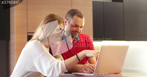 Image of Couple Using Laptop To Shop Online in modern apartment