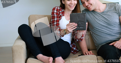 Image of Young Couple using digital tablet at home