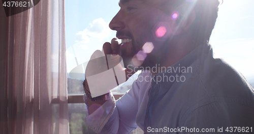 Image of Business Man Talking On Cell Phone At Home