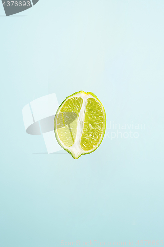Image of slice of lime isolated on blue background