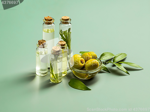 Image of Olive oil and olive branch on the wooden table