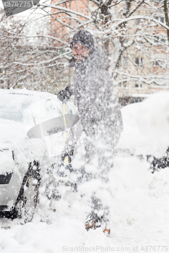 Image of Man shoveling snow in winter.
