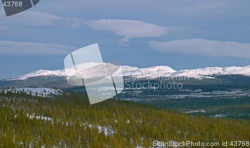 Image of White mountain with winter snow, dark sky and clouds, pine woods, V&#229;l&#229;dalen, north Sweden