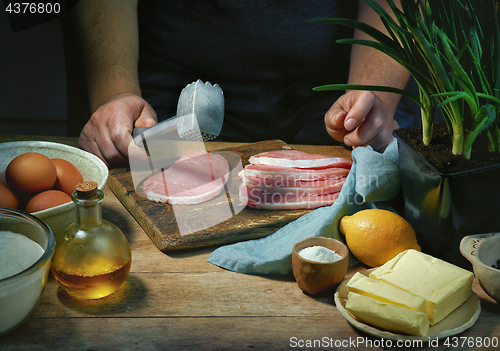 Image of cook is preparing meat