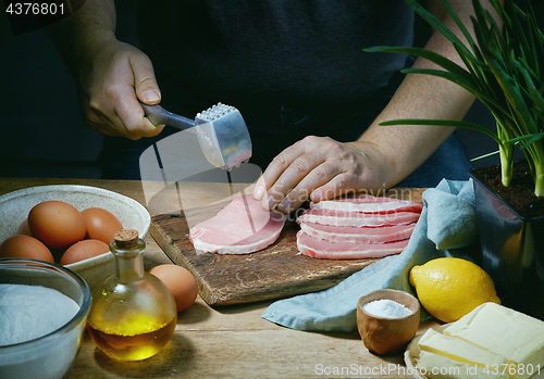 Image of cook is preparing meat