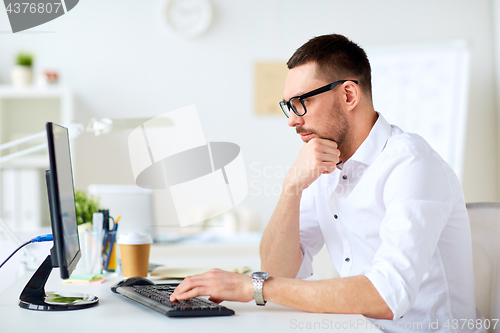 Image of businessman typing on computer keyboard at office