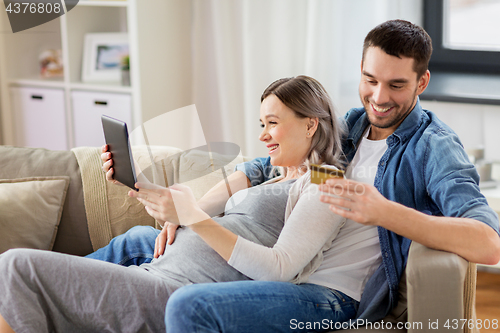 Image of man and pregnant wife shopping online at home