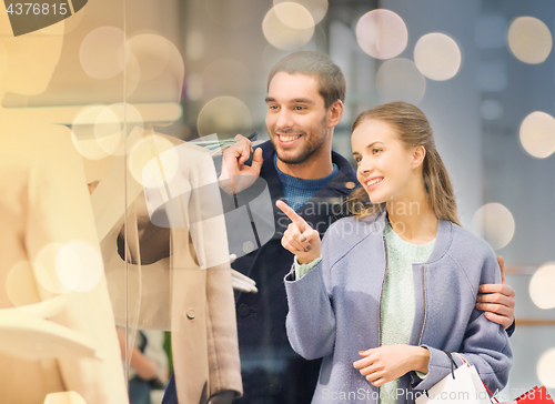 Image of happy young couple with shopping bags in mall