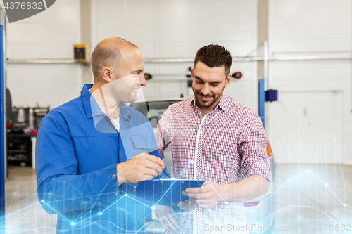 Image of auto mechanic with clipboard and man at car shop