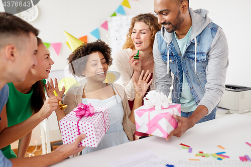 Image of team greeting colleague at office birthday party