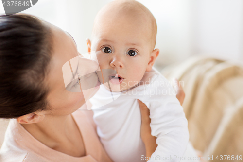 Image of happy mother kissing little baby boy at home