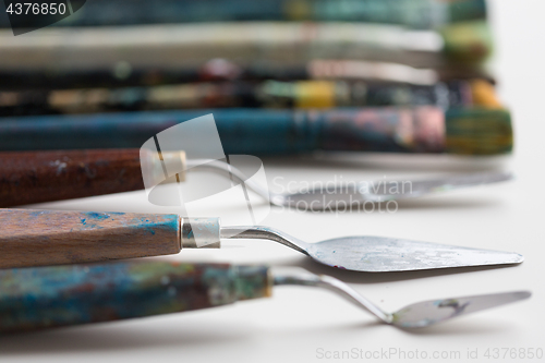 Image of palette knives or painting spatulas and brushes