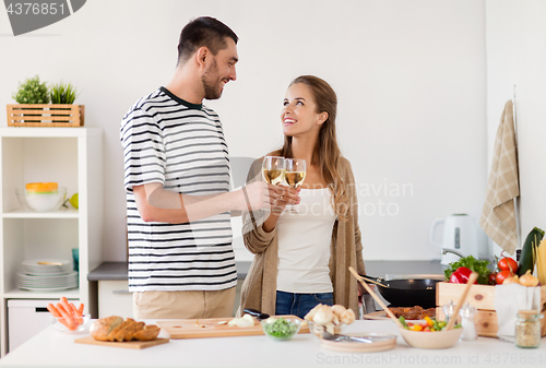 Image of couple cooking food and drinking wine at home