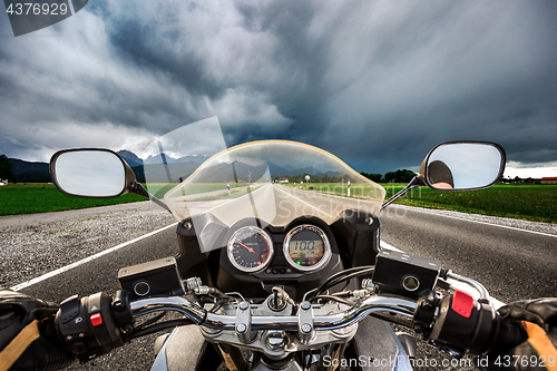 Image of Biker on a motorcycle hurtling down the road in a lightning stor