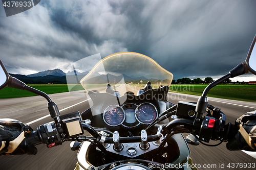 Image of Biker on a motorcycle hurtling down the road in a lightning stor