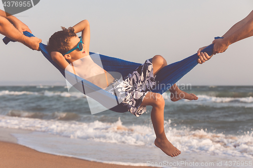 Image of Happy little boy relaxing on the beach at the day time