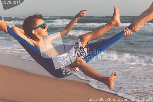 Image of Happy little boy relaxing on the beach at the day time