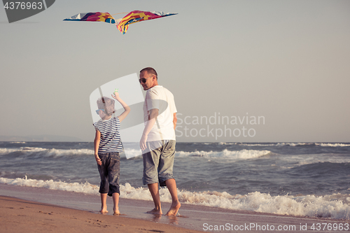 Image of Father and son playing on the beach at the day time.