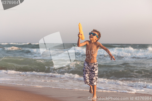 Image of One happy little boy playing on the beach at the day time.