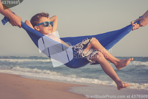 Image of Happy little boy relaxing on the beach at the day time