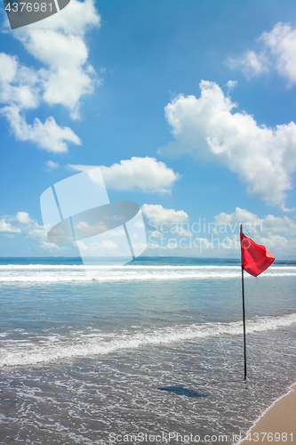 Image of a beach at Bali with a red flag