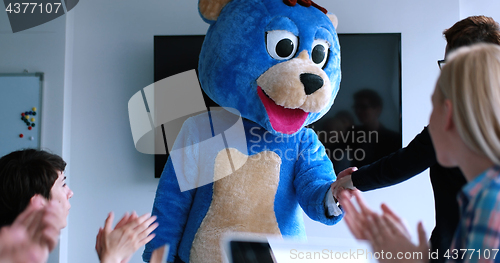 Image of boss dresed as bear having fun with business people in trendy of