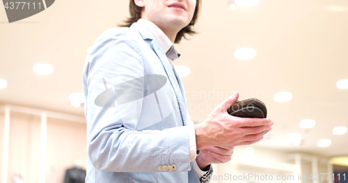 Image of Man Chooses Shoes At Shoe Store