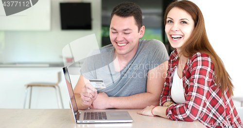 Image of Couple Using Laptop To Shop Online in modern apartment