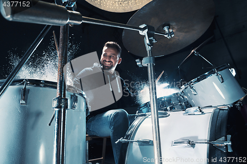 Image of Drummer rehearsing on drums before rock concert. Man recording music on drum set in studio