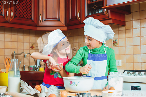 Image of happy family funny kids are preparing the dough, bake cookies in the kitchen