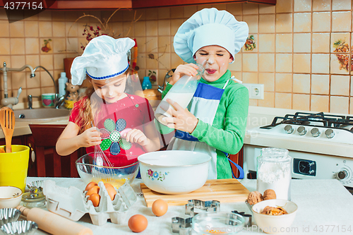 Image of happy family funny kids are preparing the dough, bake cookies in the kitchen