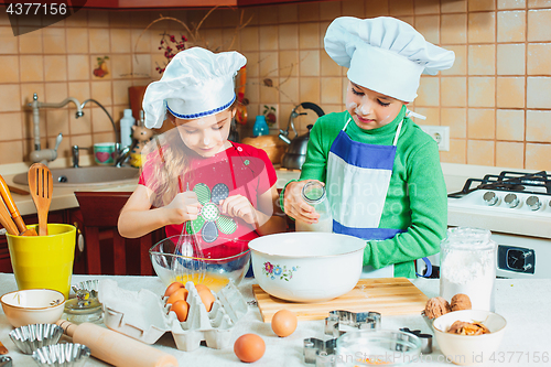 Image of happy family funny kids are preparing the dough, bake cookies in the kitchen