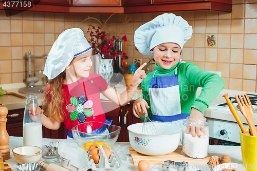 Image of happy family funny kids are preparing the dough, bake cookies in the kitchen