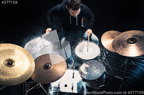 Image of Drummer rehearsing on drums before rock concert. Man recording music on drum set in studio