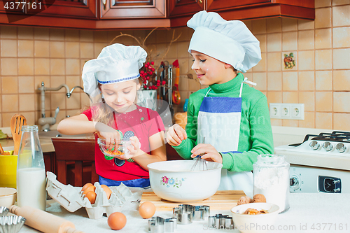 Image of happy family funny kids are preparing the dough, bake cookies in the kitchen