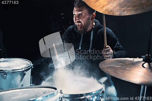 Image of Drummer rehearsing on drums before rock concert. Man recording music on drum set in studio