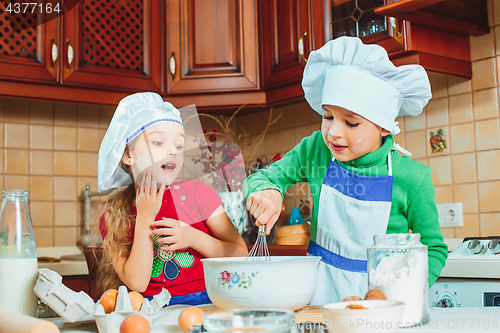 Image of happy family funny kids are preparing the dough, bake cookies in the kitchen