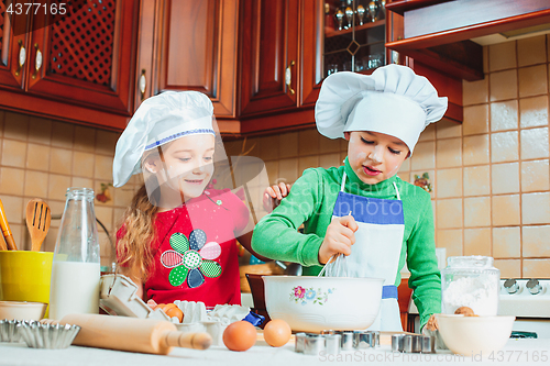 Image of happy family funny kids are preparing the dough, bake cookies in the kitchen