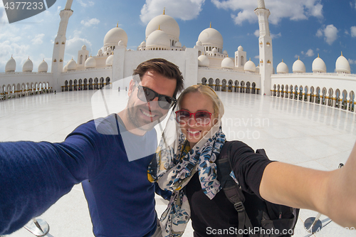 Image of Couple taking selfie in Sheikh Zayed Grand Mosque, Abu Dhabi, United Arab Emirates.