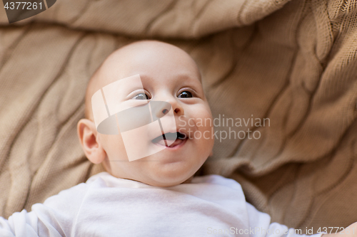 Image of sweet little baby boy lying on knitted blanket