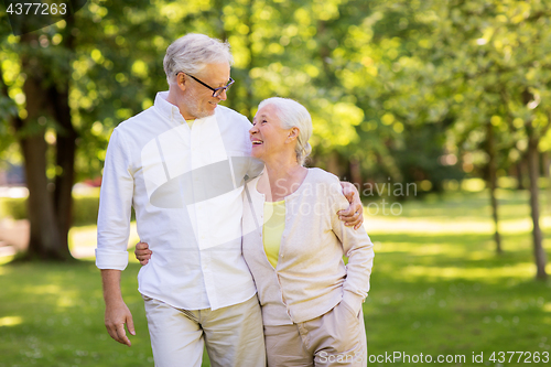 Image of happy senior couple hugging at summer park