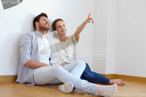 Image of happy couple at empty room of new home