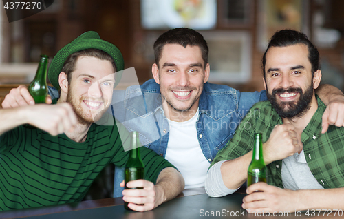 Image of happy male friends drinking beer at bar or pub