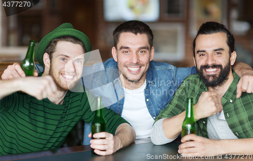 Image of happy male friends drinking beer at bar or pub