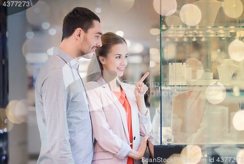 Image of couple looking to shopping window at jewelry store