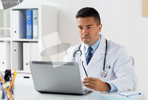 Image of male doctor in white coat with laptop at hospital