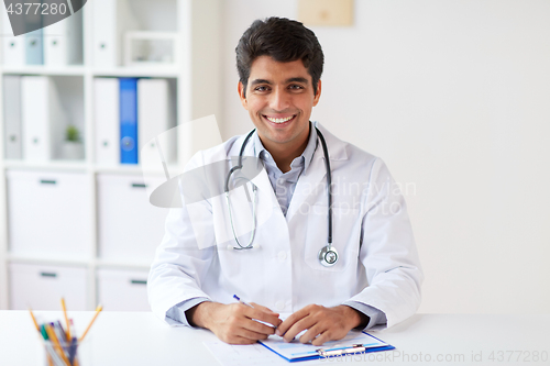 Image of happy doctor with clipboard at clinic