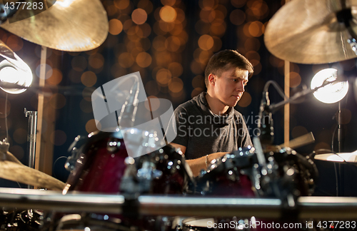 Image of male musician playing drum kit at concert