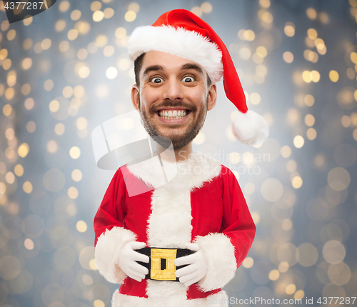 Image of man in santa claus costume over christmas lights