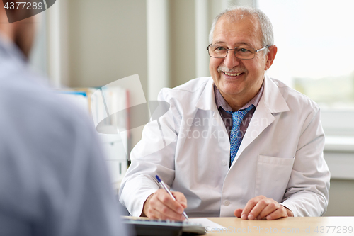 Image of senior doctor talking to male patient at hospital